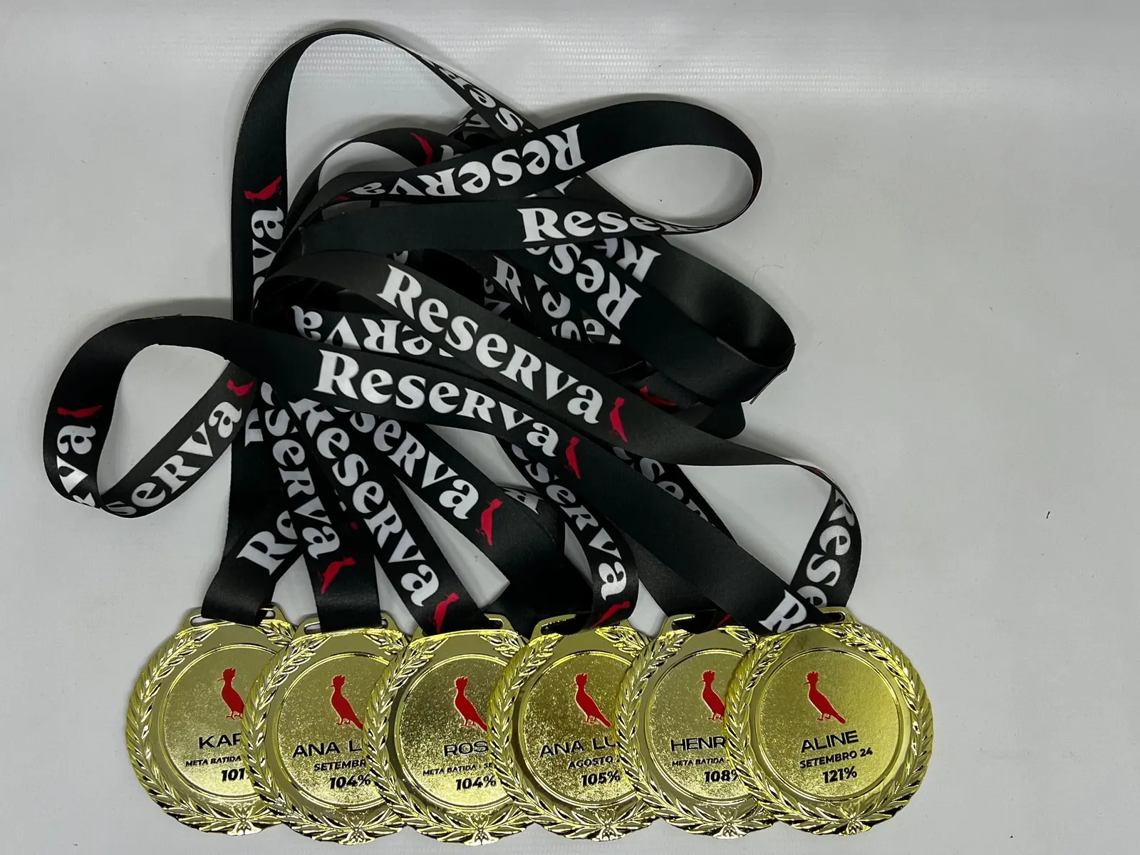 Medalhas Reserva. Metal dourado com cordão estampado com a marca